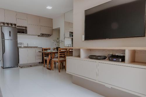 a kitchen with a large flat screen tv on the wall at Bee Guest - Apartamentos de Temporada Luxxor Flat in Cuiabá