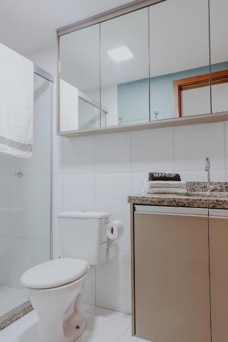 a white bathroom with a toilet and a sink at Bee Guest - Apartamentos de Temporada Luxxor Flat in Cuiabá