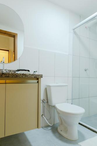 a bathroom with a toilet and a sink and a mirror at Bee Guest - Apartamentos de Temporada Luxxor Flat in Cuiabá