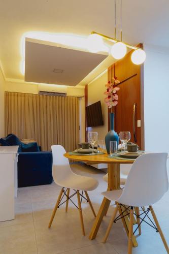 a dining room with a table and white chairs at Bee Guest - Apartamentos de Temporada Luxxor Flat in Cuiabá