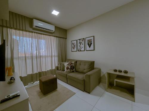 a living room with a couch and a window at Bee Guest - Apartamentos de Temporada Luxxor Flat in Cuiabá