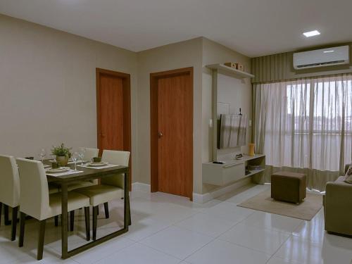a dining room with a table and chairs and a living room at Bee Guest - Apartamentos de Temporada Luxxor Flat in Cuiabá
