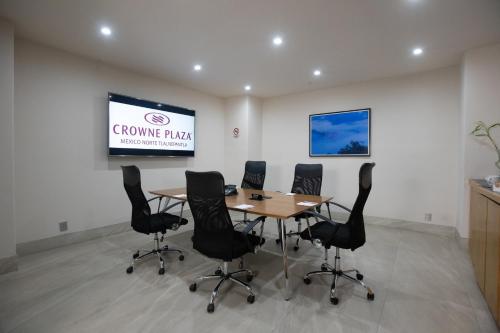 a conference room with a table and chairs and a screen at Crowne Plaza Hotel Mexico City North-Tlalnepantla by IHG in Mexico City