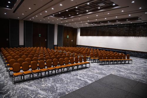 an empty auditorium with brown chairs and a screen at Crowne Plaza Hotel Mexico City North-Tlalnepantla by IHG in Mexico City