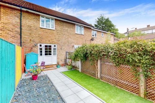 a brick house with a fence and a yard at 2 Bed with Garden & Free Parking near the Thames in London