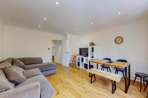 a living room with a couch and a table at 2 Bed with Garden & Free Parking near the Thames in London