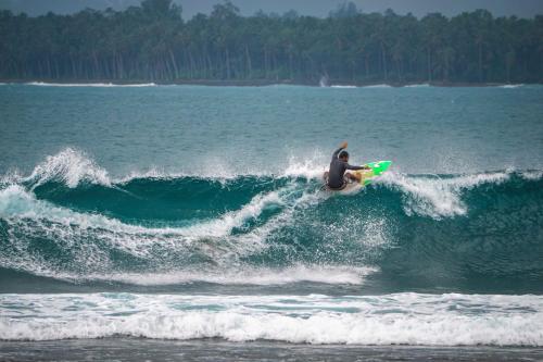 a man riding a wave on a surfboard in the ocean at Carve Bay Mentawai in Masokut