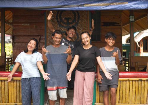 a group of people posing for a picture under a tent at Carve Bay Mentawai in Masokut