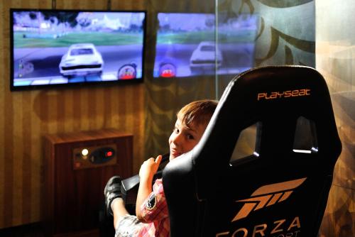 a young boy sitting in a video game controller at Wellness Hotel Chopok in Demanovska Dolina