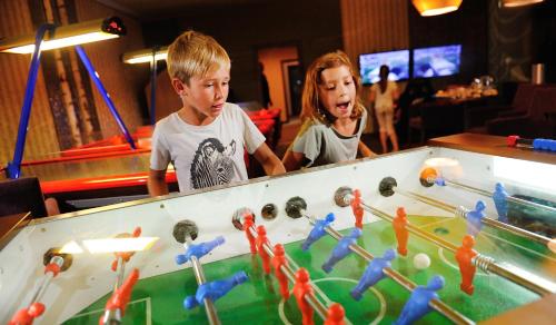 a boy and a girl playing a game of billiard at Wellness Hotel Chopok in Demanovska Dolina