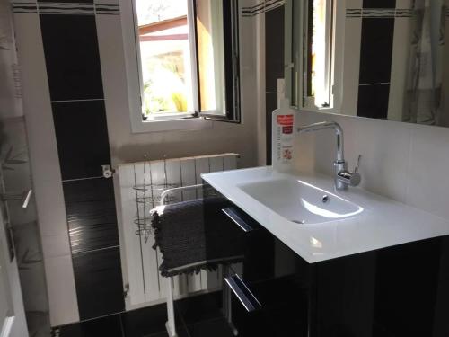 une salle de bain avec un lavabo blanc et un miroir dans l'établissement Maison charmante près des plages de Capbreton avec jardin, à Capbreton