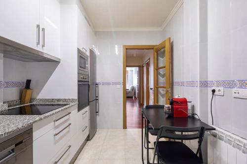 kuchnia z czarnym stołem i krzesłami w obiekcie Apartamento Lua w mieście Milladoiro