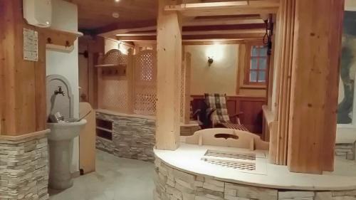 Hotel Tiroler Adler في لوتاغو: غرفة معيشة مع موقد حجري ومغسلة