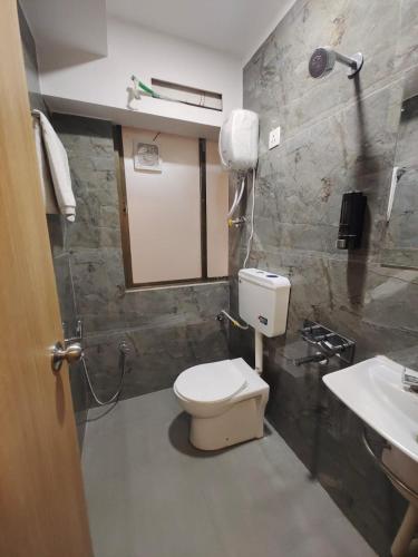 a bathroom with a toilet and a sink at Hotel PRASANG in Surat