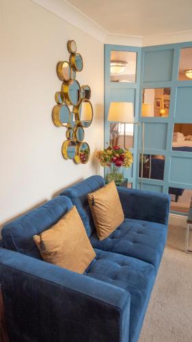 a blue couch with pillows in a living room at Riviera Lodge Hotel in Torquay
