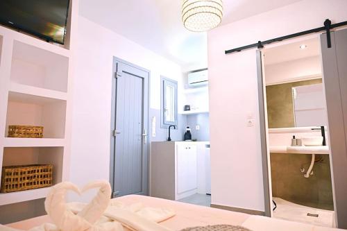 a white bathroom with a sink and a mirror at Cycladic Nest in Dryopida in Kithnos