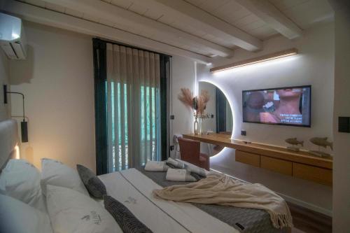 a bedroom with a bed and a tv on a wall at ALIVIO Lux Residences in Nafplio