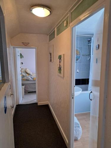 a hallway with a door leading to a bathroom at Lyndale Guest House in Weymouth