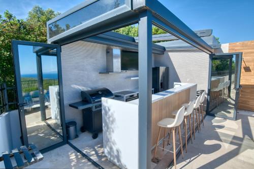 a bar with stools and a grill on a patio at Villa Azure Krimovica Kotor in Krimovice