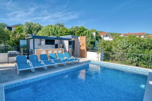 a swimming pool with blue lounge chairs and a swimming pool at Villa Azure Krimovica Kotor in Krimovice