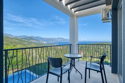 a balcony with chairs and a table and a view of the ocean at Villa Azure Krimovica Kotor in Krimovice