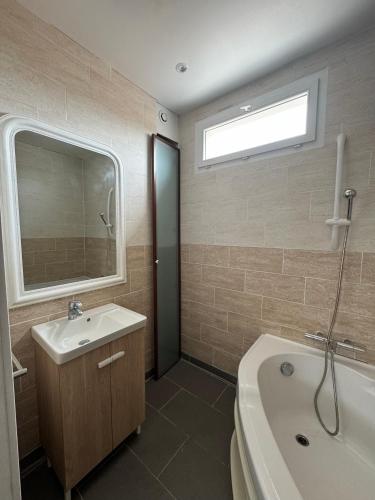 a bathroom with a tub and a sink and a bath tub at Belle maison piscine in Arles