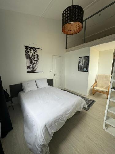 a bedroom with a white bed and a chair at Belle maison piscine in Arles