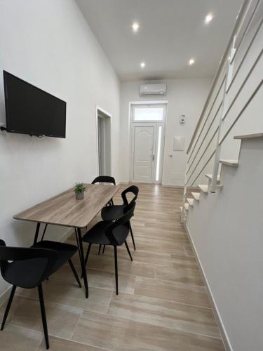 a dining room with a wooden table and chairs at Sciantusa in Avola