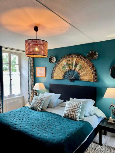 a bedroom with a large bed with a blue wall at Chambres De St Michel in Paimpol
