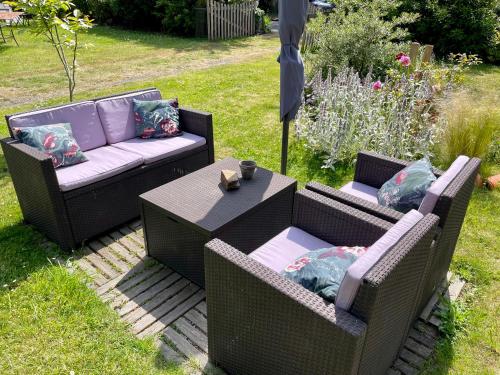 two wicker chairs and a table in a garden at Chambres De St Michel in Paimpol