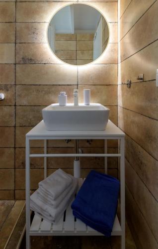 a bathroom with a white sink and a mirror at ASTERIA PEARL VILLA 2 with Rooftop Jacuzzi in Tigaki