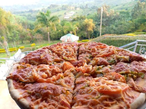 a large pizza sitting on top of a table at Top of the World Lodges Fort Portal in Fort Portal