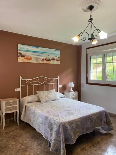 a bedroom with a bed and a painting on the wall at Casa SobreMonte in Muxia