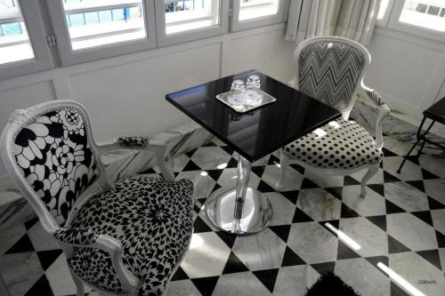 a dining room with a black table and chairs at La Villa Bleue-Sidi Bou Said in Sidi Bou Saïd