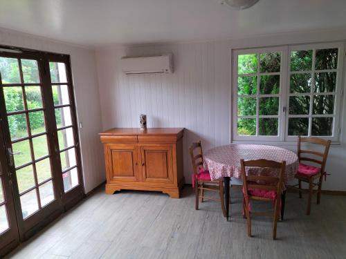 une salle à manger avec une table, des chaises et des fenêtres dans l'établissement Maison 40m 2, à Linxe