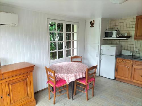 La cuisine est équipée d'une table, de chaises, d'une table et d'un réfrigérateur. dans l'établissement Maison 40m 2, à Linxe