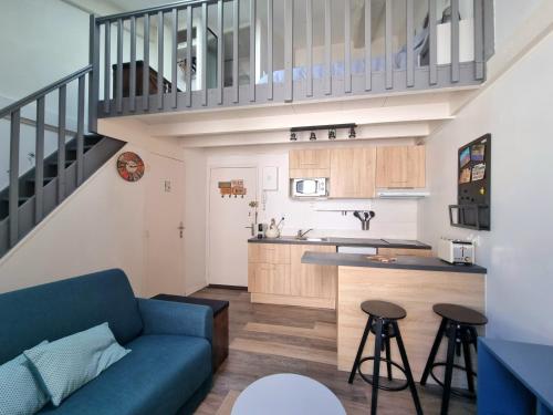 un salon avec un canapé bleu et une cuisine dans l'établissement Joli studio en plein centre historique, à Aix-en-Provence