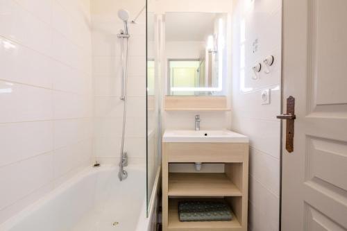 une salle de bain blanche avec lavabo et douche dans l'établissement Résidence Les Parcs de Grimaud - maeva Home - Studio 4 personnes - Sélection MAE-4361, à Grimaud