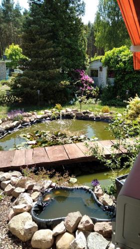 a garden with a pond and a wooden bridge at Fewo Rudow in Leuengarten