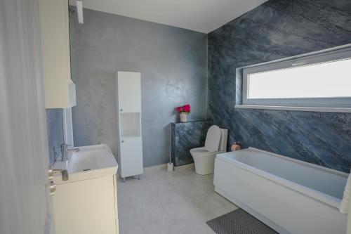 a bathroom with a tub and a toilet and a sink at Eden House 188A in Târgu-Mureş
