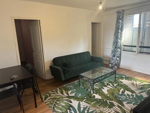 un salon avec un canapé vert et une table dans l'établissement T3 bien équipé, à Marseille