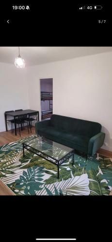 un salon avec un canapé vert et une table dans l'établissement T3 bien équipé, à Marseille