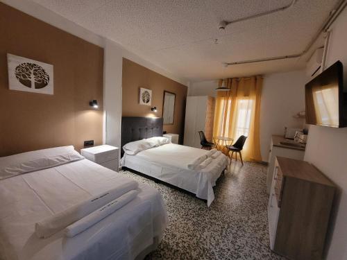 a hotel room with two beds and a table at Hotel Arganda in Arganda del Rey