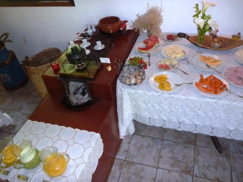 een tafel met borden eten erop bij Pousada Passaredo in Gonçalves