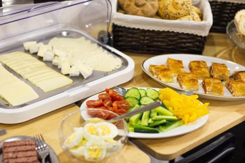 a table topped with plates of cheese and vegetables at Hotel Vincent in Luhačovice