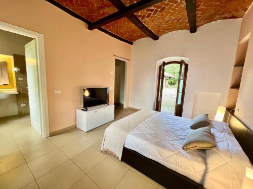 a bedroom with a large bed and a television at Borgo del 1700 Le Scuderie - bilocale in Travedona