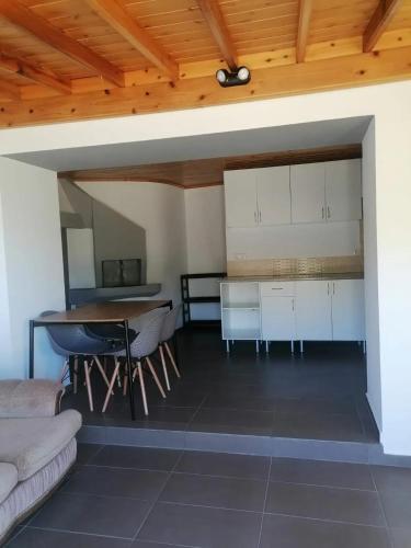 a living room with a table and a kitchen at Comfortable house with sea view in São Roque do Pico in São Roque do Pico