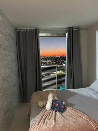a bedroom with a bed and a window with a view at Pôr do Sol DF Plaza in Brasília
