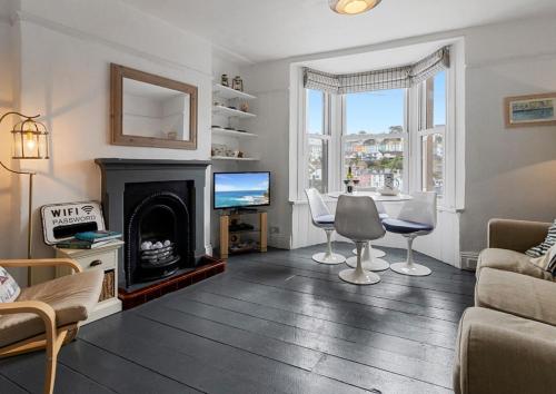 a living room with a fireplace and a tv at Limpet Cottage - Beautiful Space & Close To Town in Brixham