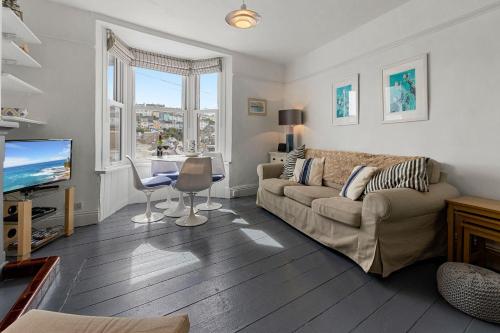 a living room with a couch and a tv at Limpet Cottage - Beautiful Space & Close To Town in Brixham